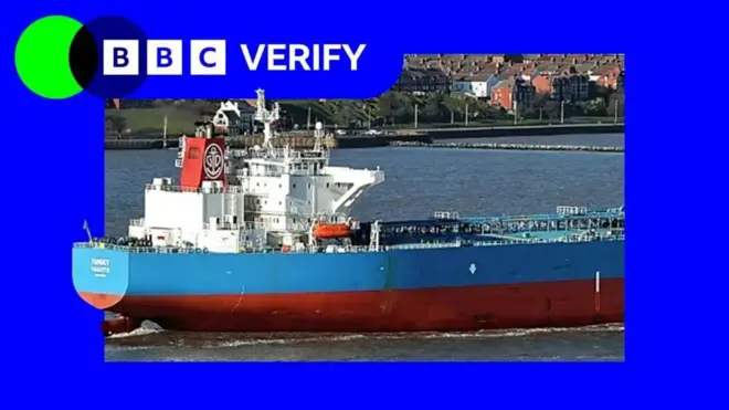 Танкер Forwarder стоит на якоре в порту. На изображении судно наложено на фоне фирменных цветов и логотипа BBC Verify.